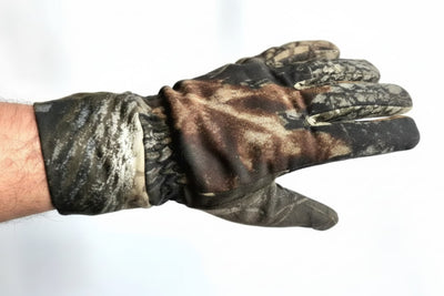 A camouflage hunting glove worn on a person's hand, shown against a plain white background.