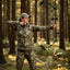 Person in camouflage attire with a bow in a forest setting