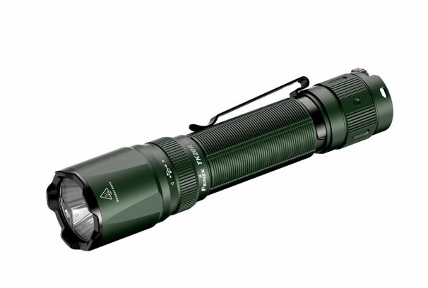 A tactical flashlight in matte dark green with a black clip and black bezel, shown at a diagonal angle on a plain white background.