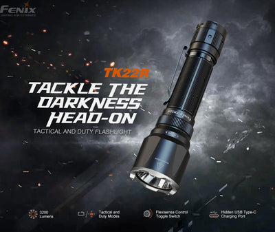 A Fenix TK22R tactical flashlight shown at an angle against a dark smoky background with text reading 'TACKLE THE DARKNESS HEAD-ON' and feature callouts at the bottom.