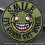 Embroidered patch with a smiley face and text 'SMILE IT'S GONNA GET WORSE' on a green background.