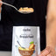 Person holding a spoonful of food above a radix breakfast package.