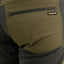 Close-up of a green jacket with a zipper pocket and 'Swazi' brand logo.
