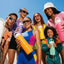 Group of people holding colorful water bottles with a clear blue sky in the background