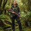 Person in camouflage clothing holding a rifle in a forest setting