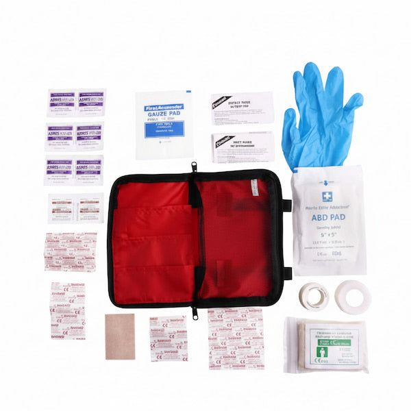A first aid kit contents layout on a white background, featuring a red zippered case, blue gloves, an ABD PAD, gauze pads, bandages, tape, and other medical supplies.
