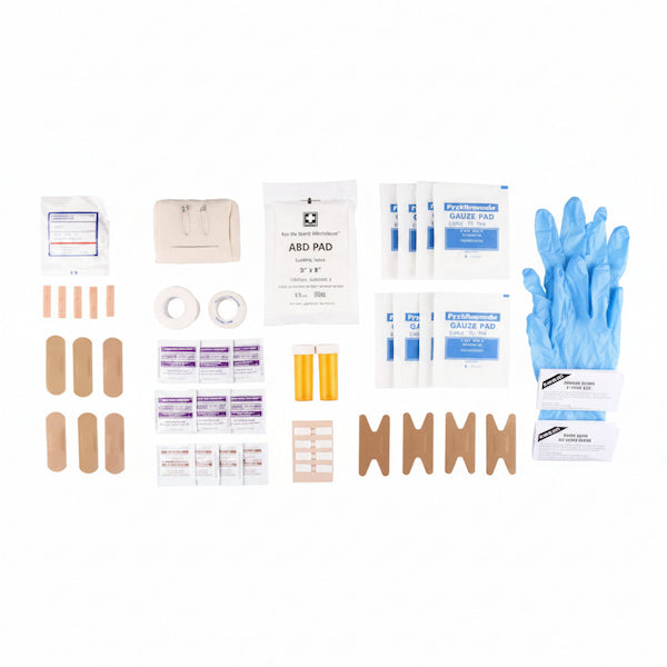 A first aid kit contents layout on a white background, including bandages, adhesive pads, gauze, tape, yellow tubes, and blue gloves.