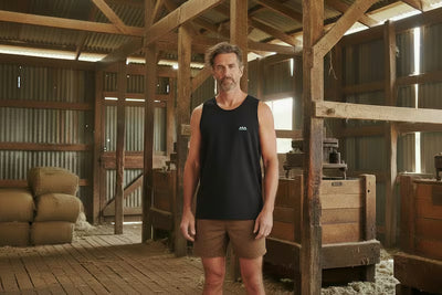 Man standing in a rustic wooden interior space with beams and wooden furniture.