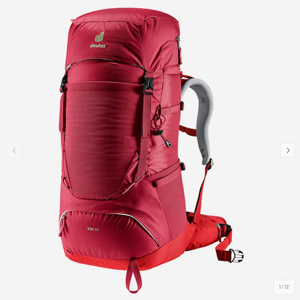 A red Deuter hiking backpack shown from a three-quarter front angle against a light gray background.