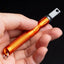 Orange pen light held in a hand against a black background