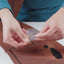 Person applying a patch to a leather surface with a visible stain.