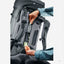 Gray hiking backpack with a person adjusting the straps on a white background