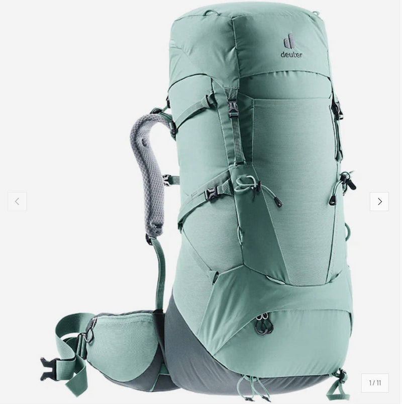 A Deuter hiking backpack in a muted sage green color, shown from a three-quarters front angle against a plain white background.
