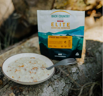 Back Country Elite African Rice Pudding package with a bowl of pudding on a natural surface