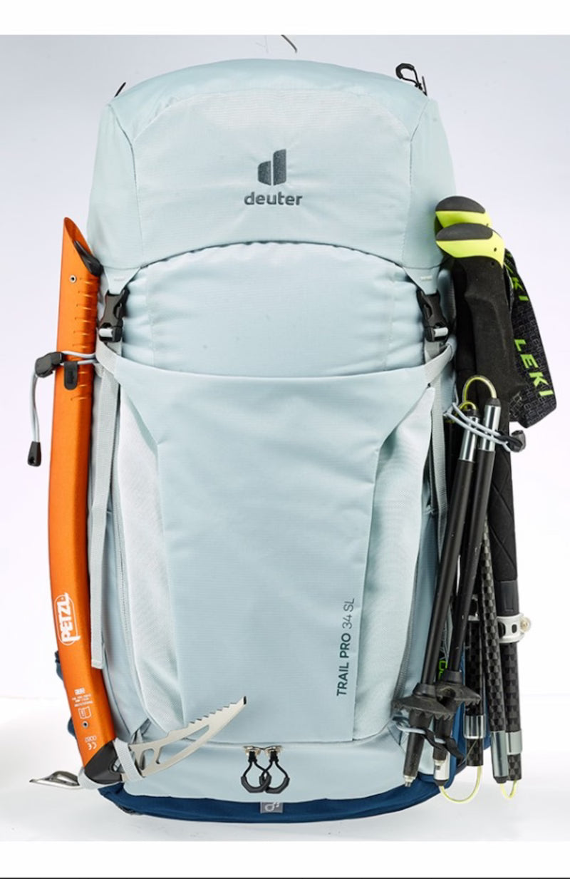 Light blue hiking backpack with attached ski poles and a ski on a white background
