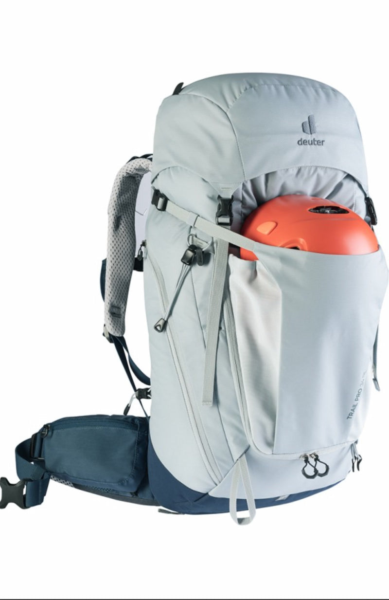 Gray hiking backpack with orange helmet inside on a white background