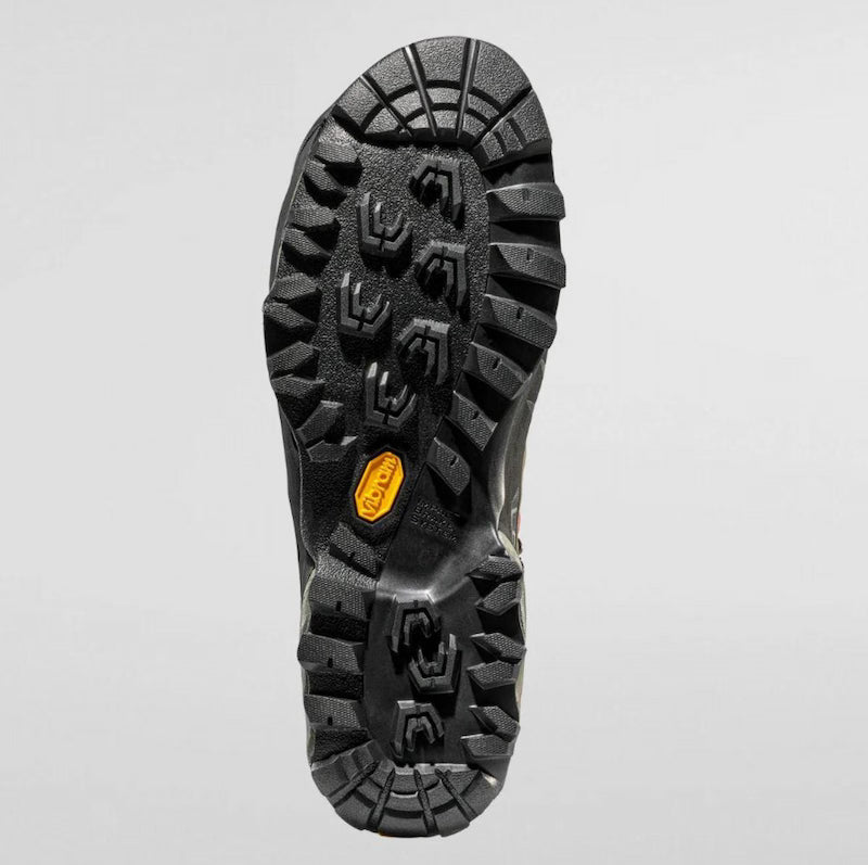 Close-up of a black hiking boot sole with tread pattern on a gray background