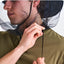 Person wearing a green shirt with a black insect netting over their head against a white background