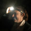 Person wearing a headlamp in a dark setting