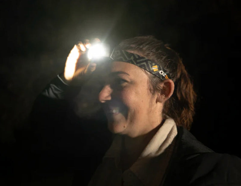 Person wearing a headlamp in a dark setting