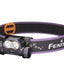 Fenix headlamp with purple band on a white background
