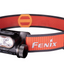 Fenix headlamp with orange strap on a white background