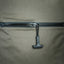 Black metal rod with a hook on a gray fabric background
