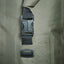 Close-up of a green backpack with a black buckle and strap.