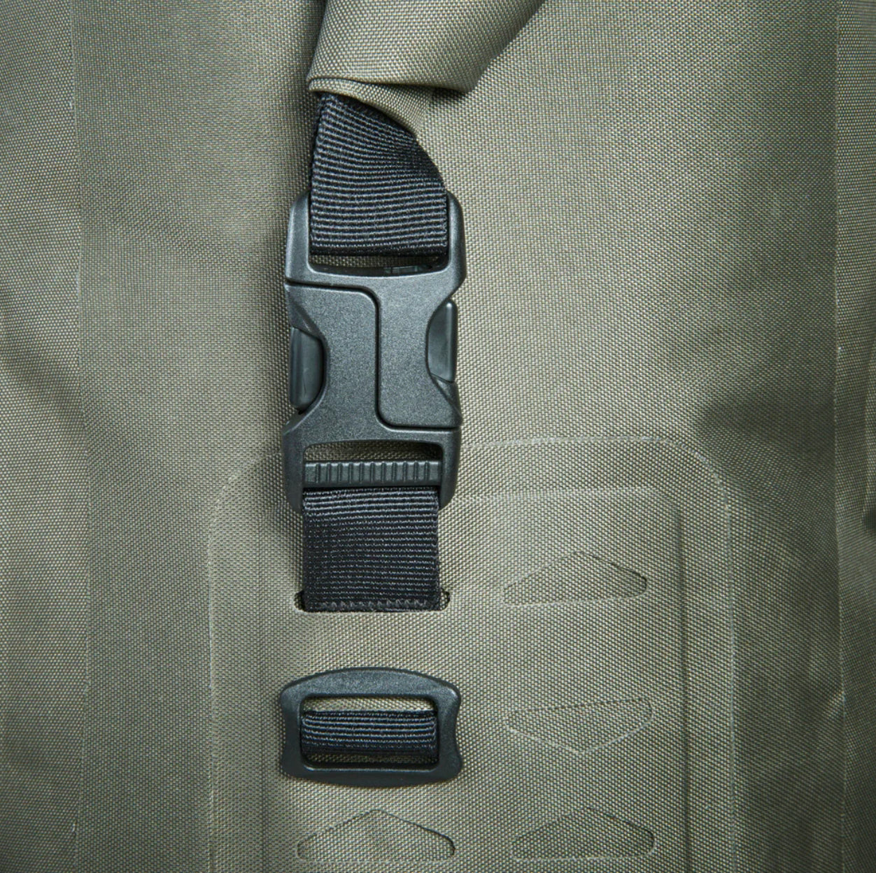 Close-up of a green backpack with a black buckle and strap.