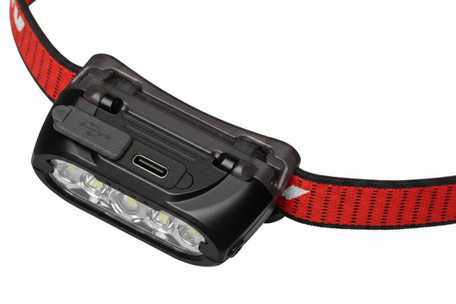 Close-up of the back of a black smart headlamp with a red and black braided cord on a white background.