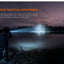 A tactical flashlight beam illuminates a lake at night, with a person standing in the foreground holding the flashlight. Orange promotional text appears on the left side of the image.