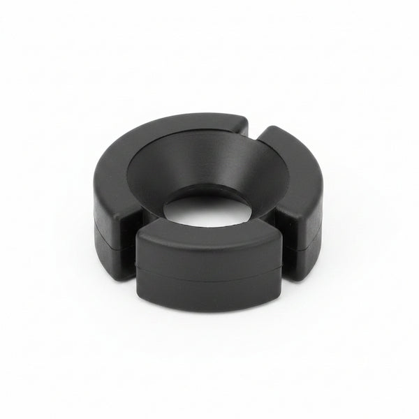 A black circular plastic ring with a central hole and three outer flanges, photographed on a clean white background.