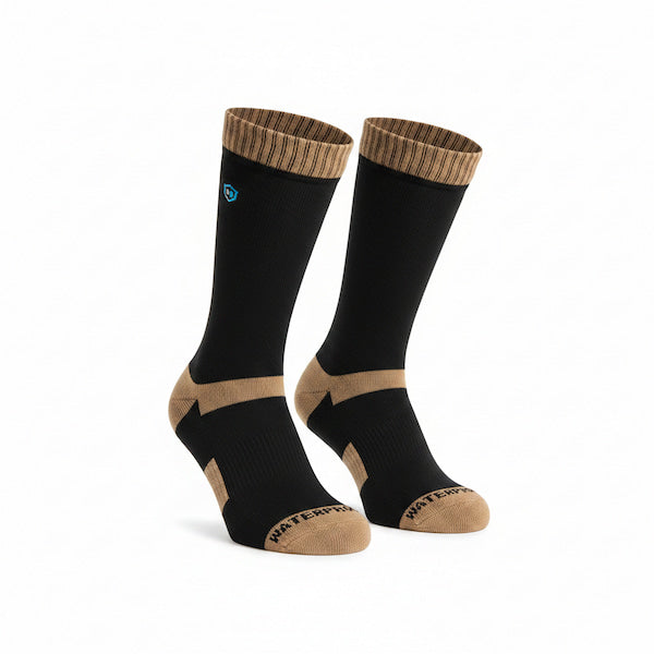 A pair of crew socks in black with tan accents on the heel, toe, and ribbed cuff, featuring a small blue circular logo on one sock.