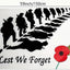 Decorative wall art with silhouettes of soldiers, a poppy flower, and 'Lest We Forget' text on a white background.