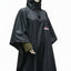 A mannequin wearing a black hooded rain poncho with a small red and white logo patch on the chest, shown against a plain white background.