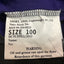 A close-up of a white garment size label sewn onto a dark purple shirt, showing text including 'SIZE 100' and a warning about oil and grease.