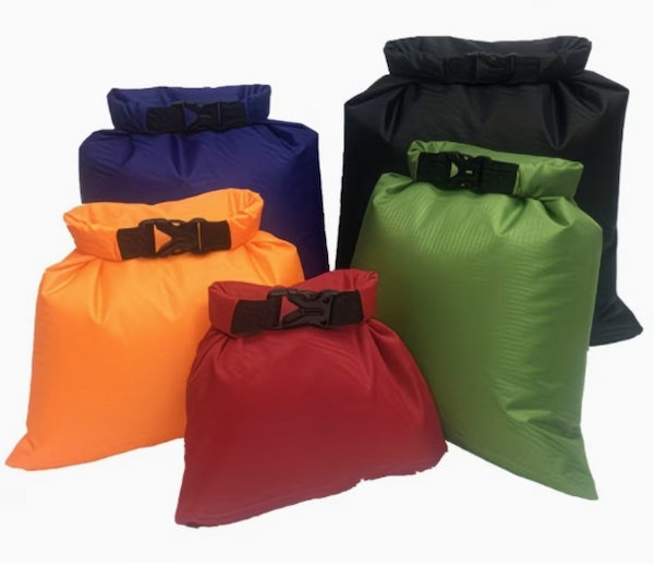 Five colorful dry bags with buckles on a white background