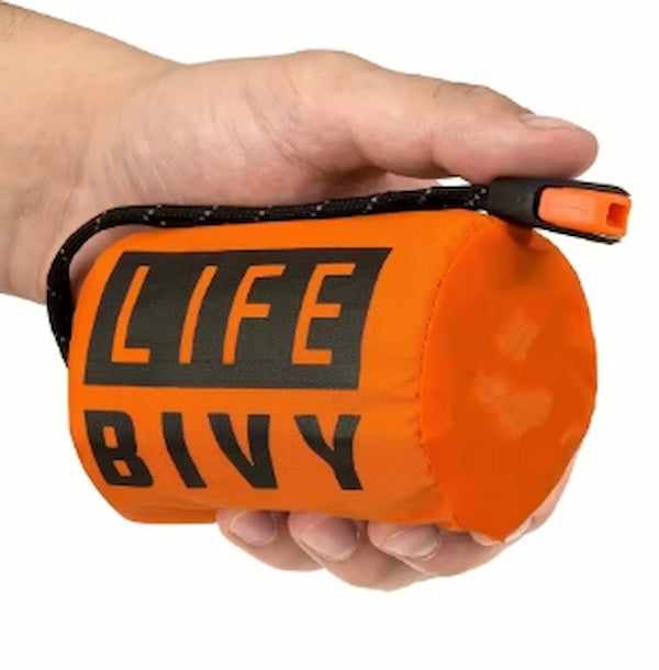 Orange 'LIFE BIVY' bag held in a hand against a white background