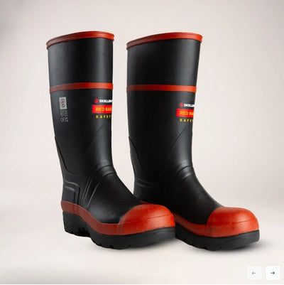 Black rubber boots with red soles on a light gray background