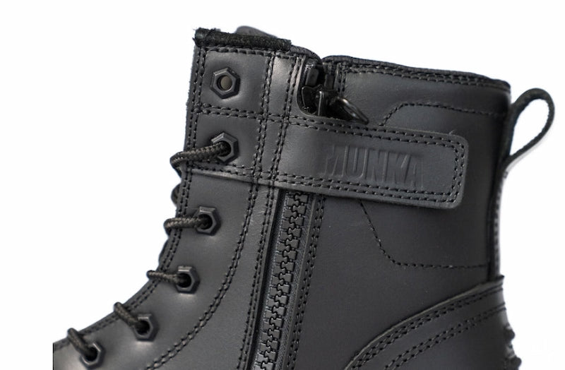 Close-up of a black leather lace-up boot with a side zipper, pull tab, and a strap across the ankle featuring the embossed brand name HUNTA.