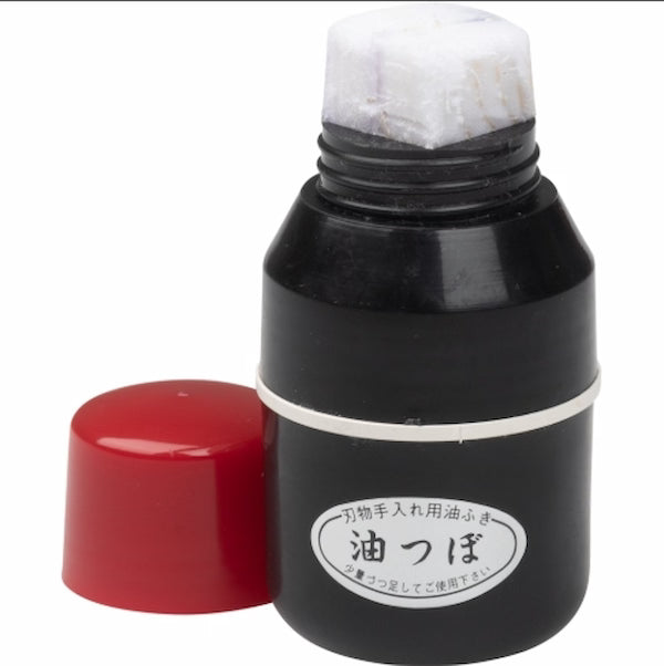 Black ink bottle with red cap on a white background