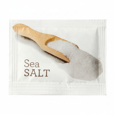 Packaged sea salt with a wooden scoop on a white background